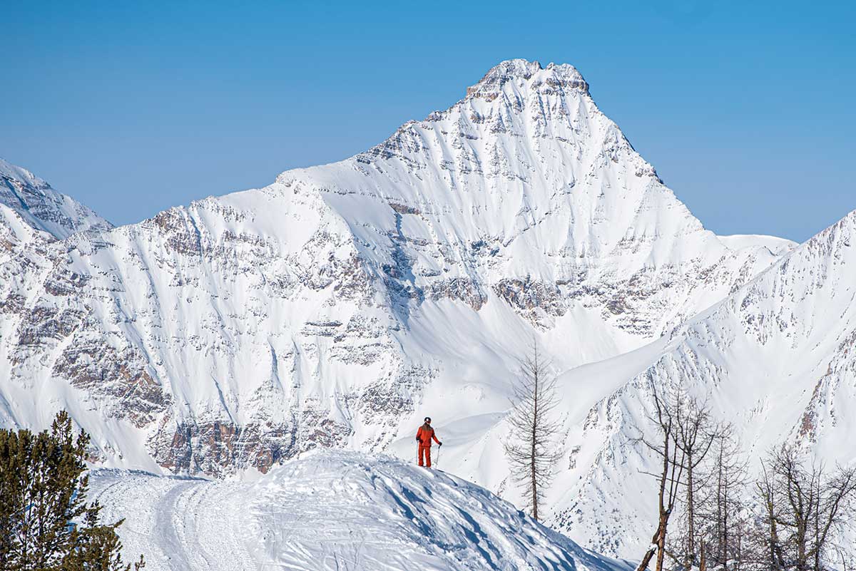 A lone skier stands beneath one of the towering peaks surrounding Panorama Mountain Resort. Photo courtesy PMR.