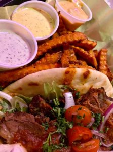 Jambo Cafe’s lamb sandwich, sweet potato fries, and dipping sauces.