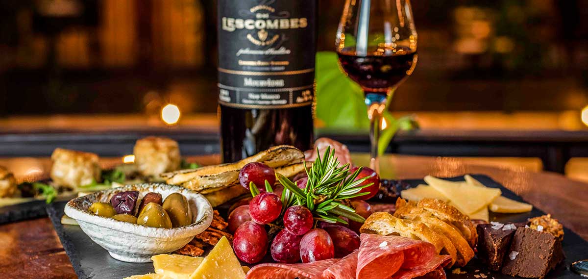 A food platter and bottle of wine at Hervé Wine Bar in Santa Fe, part of the D. H. Lescombes Family Vineyards.