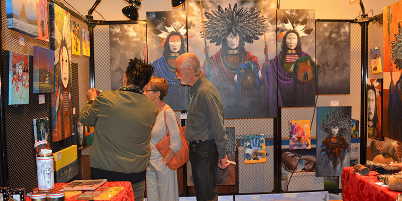People looking at art at Native Treasures Art Market and Auction.