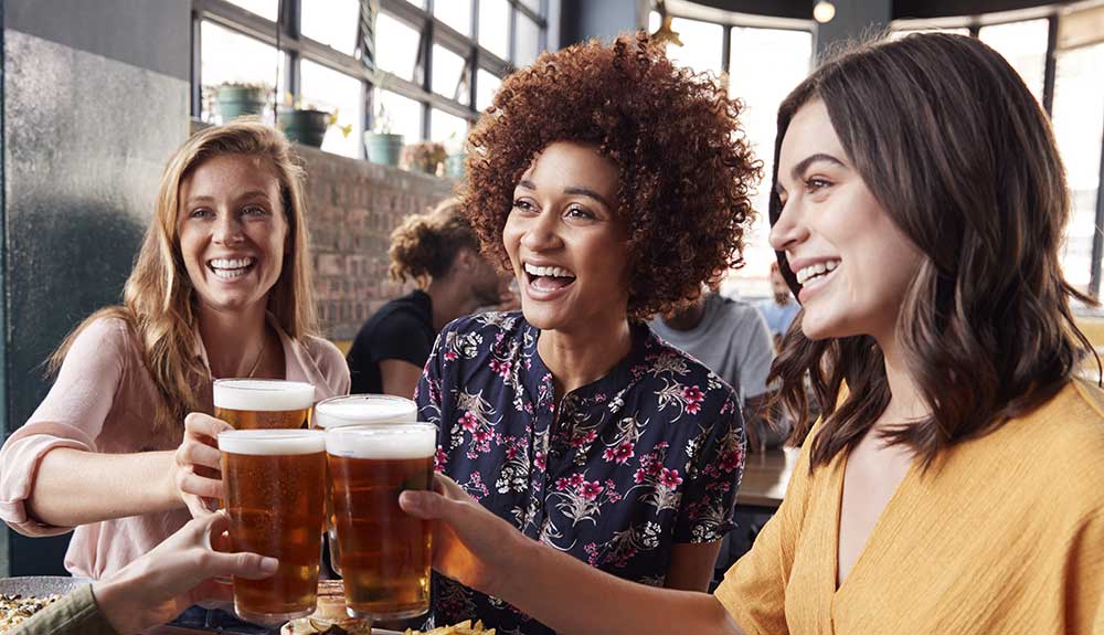 Young women toasting with beer