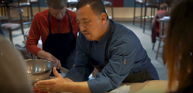 cooking instructor showing students technique with red peppers