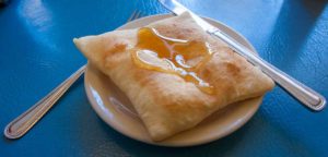 Sopaipilla on a plate dripping with honey.